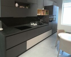 Cocina en negro con unos de los cajones en blanco